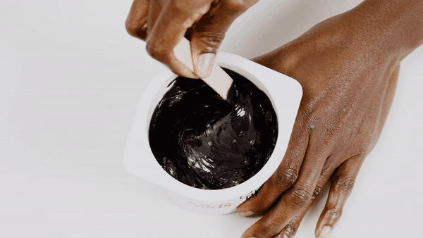 Woman stirring Nad's Charcoal Bead Wax