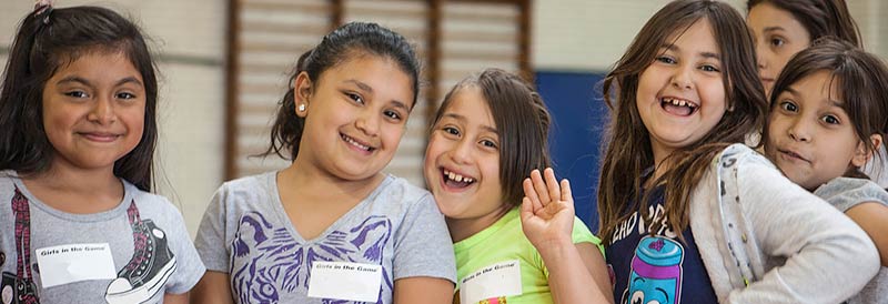 Girls in line for sports smiling and posing for camera